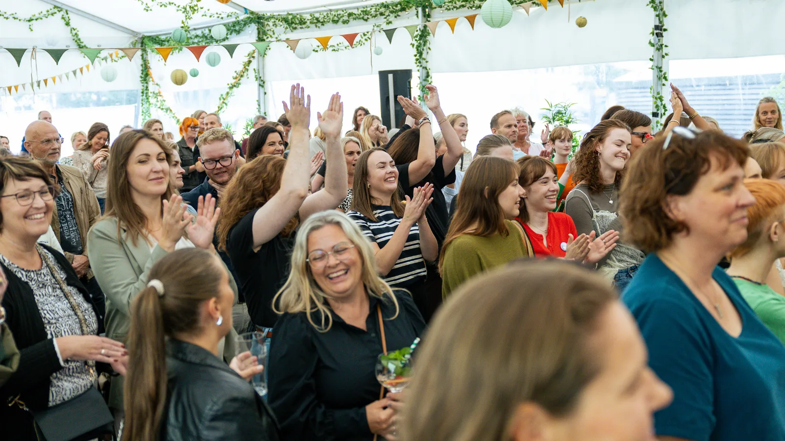 Publikum som klapper og jubler under en sommerfest i festtelt